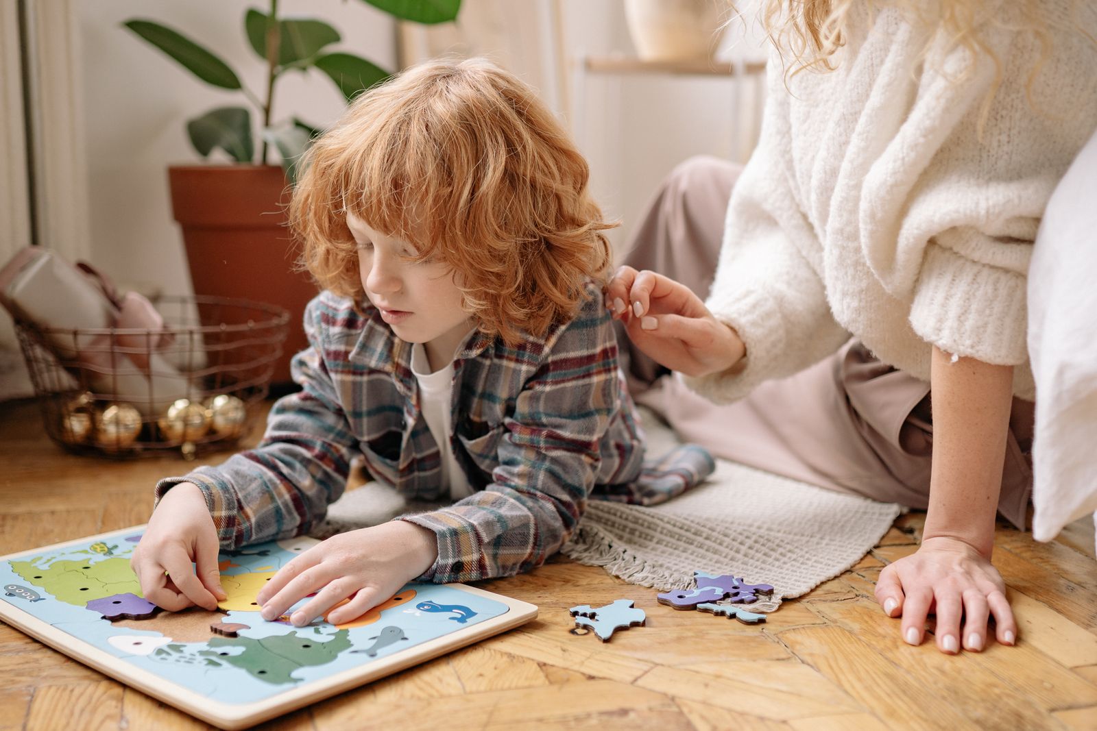 Une mère qui accompagne son fils dans un casse-tête, au sol, dans un salon chaleureux